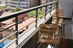 Enjoy a peaceful moment on this balcony with two comfortable chairs.