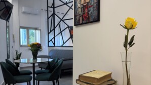 A modern office space with a wooden table, a vase with a yellow rose, and a framed abstract painting on the wall. - La Dimora del Centro - Agrigento Complete apartment in the heart of the City (Agrigento)