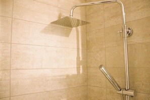 Chuveiro, secador de cabelo, toalhas de banho, shampoo
