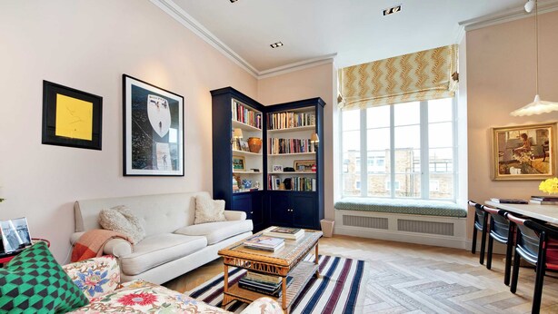 A living room with a sofa, a coffee table, a bookshelf, and a window with a view. - Charming 2 Bedroom 2 Bathroom, Notting Hill (London)