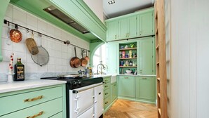 A kitchen with green cabinets, a white stove, and wooden flooring. - Charming 2 Bedroom 2 Bathroom, Notting Hill (London)