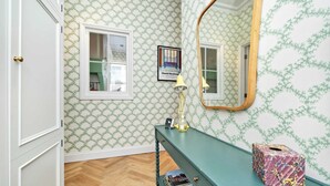 A room with patterned wallpaper, a mirror, a desk with books, and a tissue box. - Charming 2 Bedroom 2 Bathroom, Notting Hill (London)