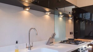 A modern kitchen with a white countertop, stainless steel sink, and a gas stove. - Stylish 1-bed With a Roof Terrace (London)