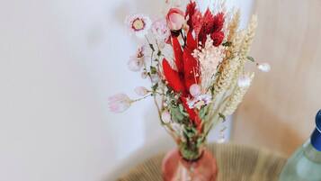 Une table avec un vase de fleurs et une bouteille.