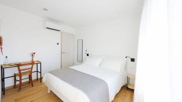 A bedroom with a bed, a desk, and a chair.