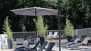 Relax by the pool surrounded by lush greenery and comfortable lounge chairs.