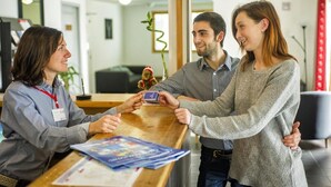 Un comptoir d’accueil avec un réceptionniste, un client et un homme.