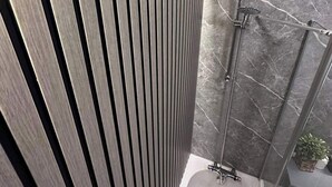 A modern bathroom with a freestanding bathtub, a glass shower enclosure, and a wooden panel wall. - 2br-sleeps4-freeparking-wifi-smarttvs (Manchester)