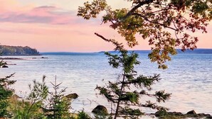 A coastal landscape with trees and a view of the water. - Beachfront House w/Fire Pits & Ocean Views, (Ellsworth)