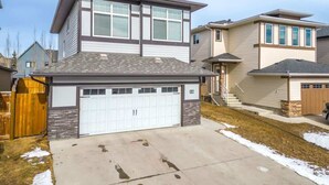 A residential house with a garage, a two-story structure, and a visible number '16' on the side. - The Grande 1BD 1BA - Full Kitchen Guest Suite (Calgary)