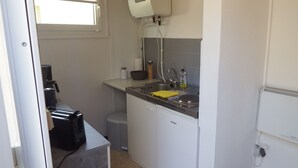 A compact kitchen with a sink, a coffee maker, and a compact refrigerator. - Vacation cottage in the countryside approx. 150 m from the SpreewaldTherme-M (Burg (Spreewald))