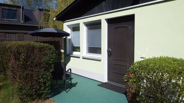 A house with a green door, a window with blinds, and a black umbrella. - Vacation cottage in the countryside approx. 150 m from the SpreewaldTherme-M (Burg (Spreewald))