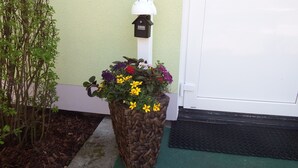 A planter with a variety of flowers in front of a white door. - Vacation cottage in the countryside approx. 150 m from the SpreewaldTherme-M (Burg (Spreewald))