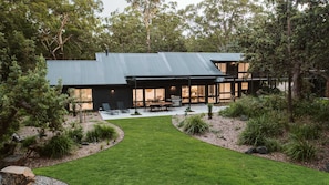 Una casa moderna con un ampio patio, una piscina e un giardino curato.