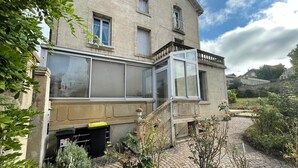 A two-story building with a stone facade, a covered porch, and a brick pathway leading to the entrance. - L'Arpège du Puy - House* ParkingView * Family* 10min walk from Center (Le Puy-en-Velay)