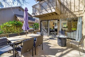 Un patio exterior con una mesa, sillas, un jacuzzi y una zona de estar cubierta.