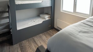 A bunk bed room with a window, wooden flooring, and a ceiling light fixture. - Vibe Apartment 4, Lord Street (Blackpool)
