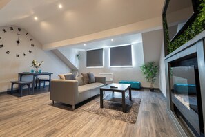 A modern living room with a sofa, coffee table, and a clock on the wall.