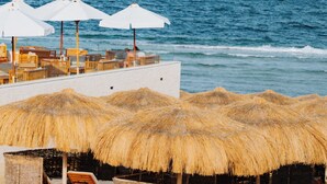 A beachside lounge with thatched umbrellas and wooden lounge chairs, overlooking the ocean. - Diamond Beach (El Quseir)