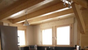 A kitchen with wooden cabinets, a refrigerator, a microwave, and a sink. - Chalet, wifi, view mountain, terrace, balcony, parking, ski locker, 152m², Le Grand Bornand (Le Grand-Bornand)