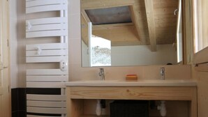 A modern bathroom with a wooden vanity, a large mirror, and a black tiled floor. - Chalet, wifi, view mountain, terrace, balcony, parking, ski locker, 152m², Le Grand Bornand (Le Grand-Bornand)