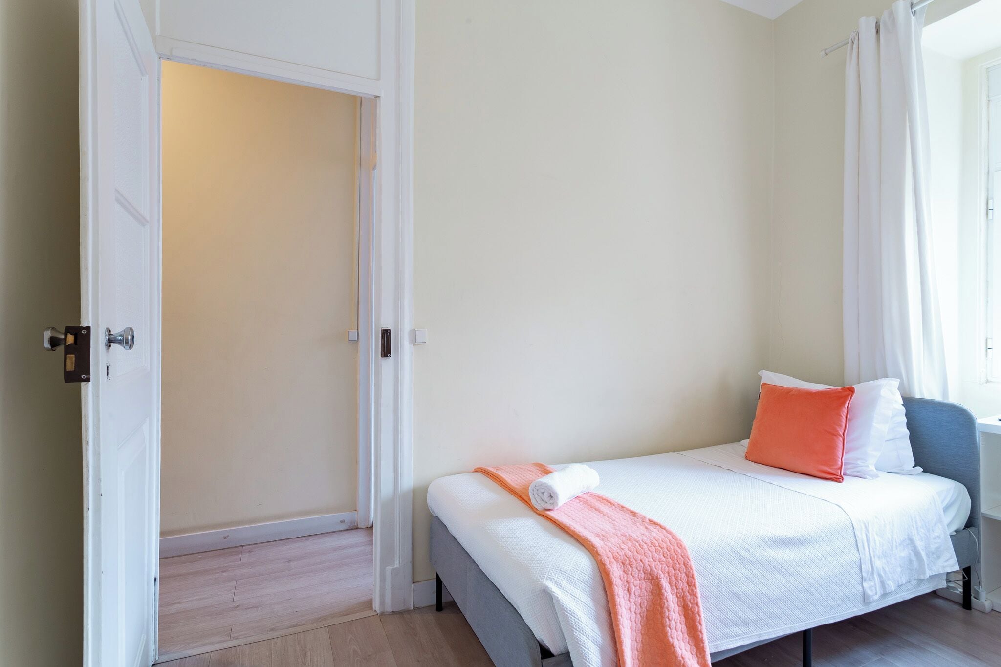 Une chambre à coucher avec un lit, une porte et une fenêtre.