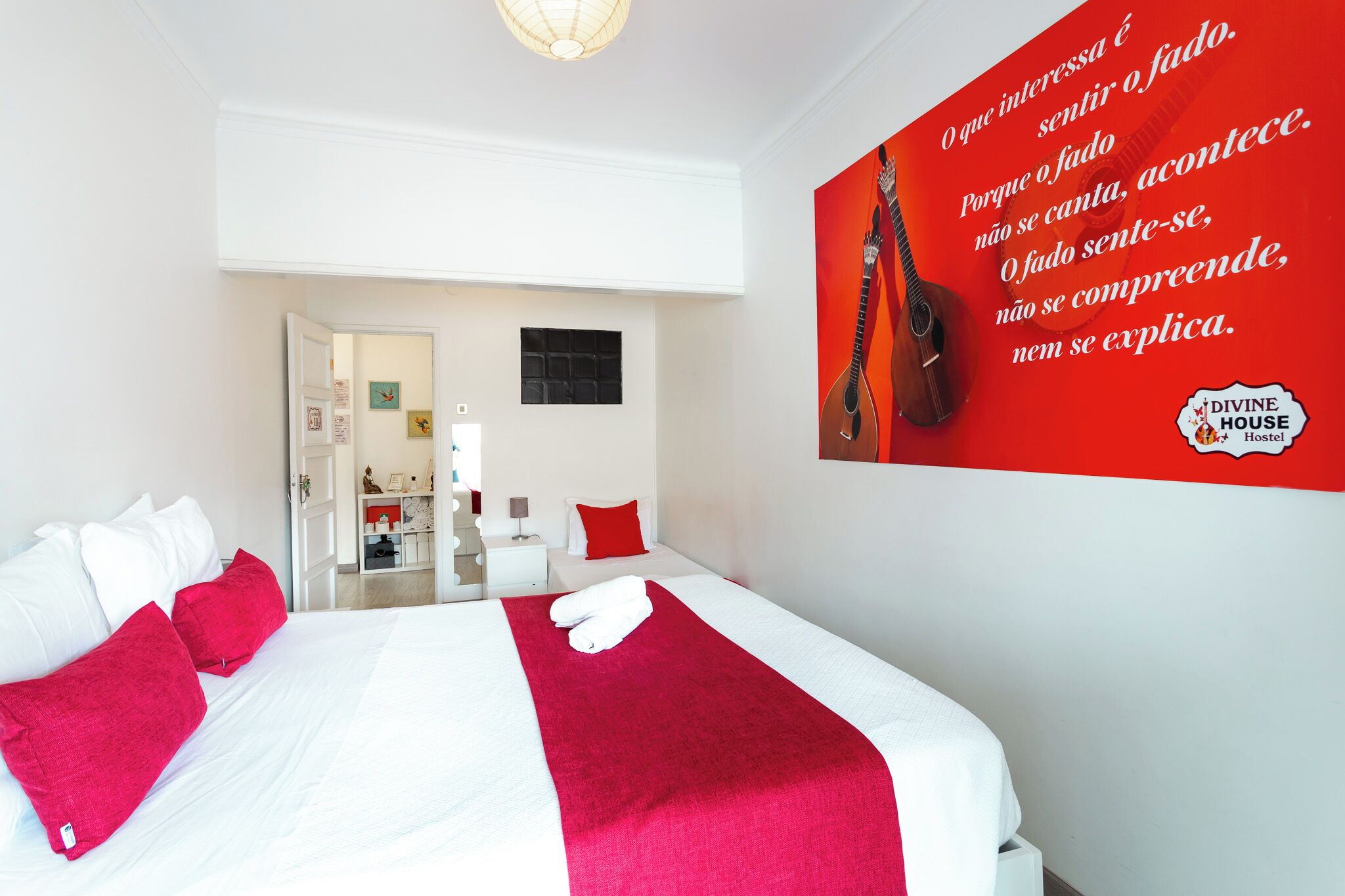 Una habitación de hotel con cama, almohadas, una pared roja y una cita.