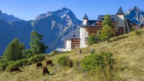 A mountain resort with chalet-style buildings, a hiking trail, and grazing cows. - 200m from ski slopes, fitness, balcony, parking, tv, ski locker, 22m², Les 2 Alpes (Les Deux Alpes)
