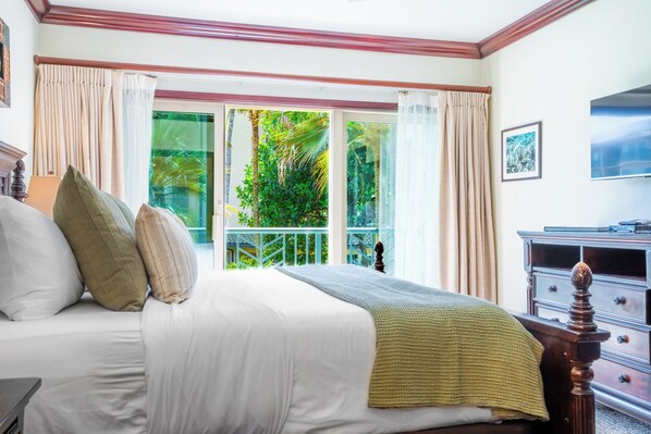 A bedroom with a bed, a dresser, and a window with curtains. - New Listing: Waipouli Beach Resort, Pool, AC, Gym & more (Kapaa)
