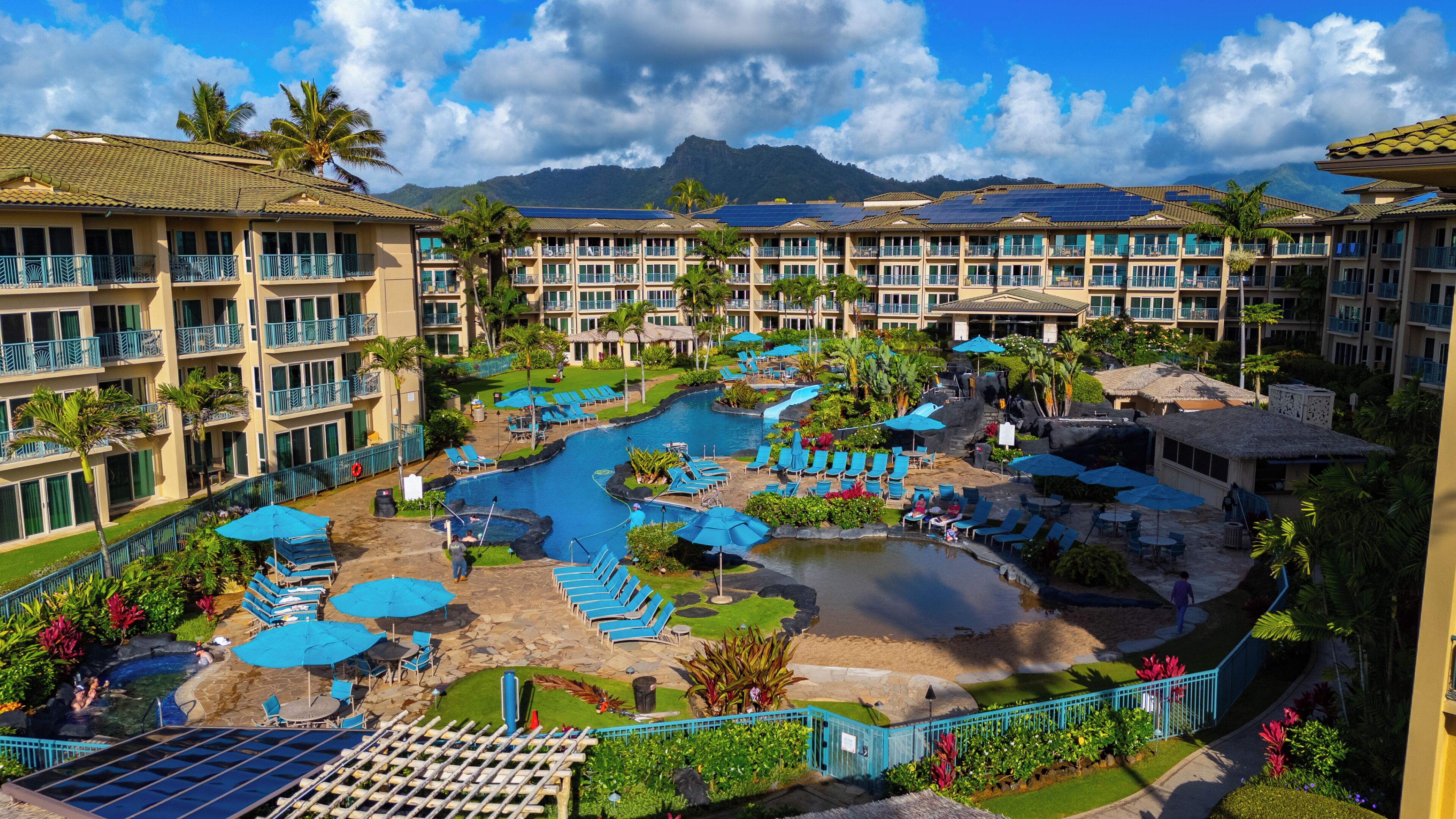 Un complexe hôtelier doté de plusieurs piscines, de chaises longues et offrant une vue sur un paysage montagneux.
