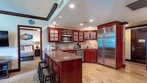A modern kitchen with wooden cabinets, stainless steel appliances, and a central island with bar stools.