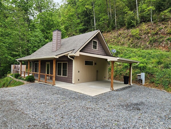 Une maison à deux étages avec un porche couvert, une cheminée et un garage.
