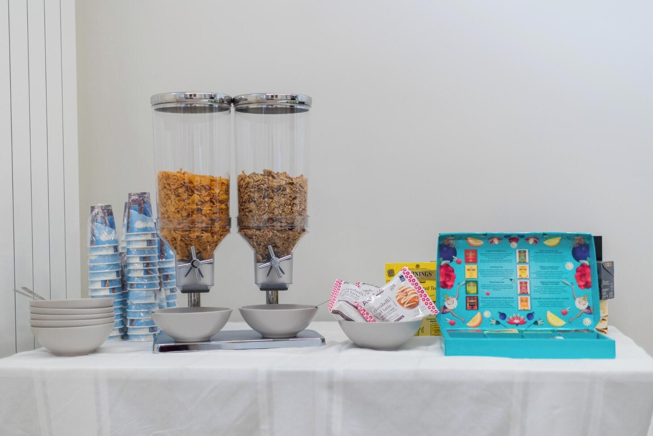Montaje de bufé con dos dispensadores de alimentos, cuencos y un atril para menús.