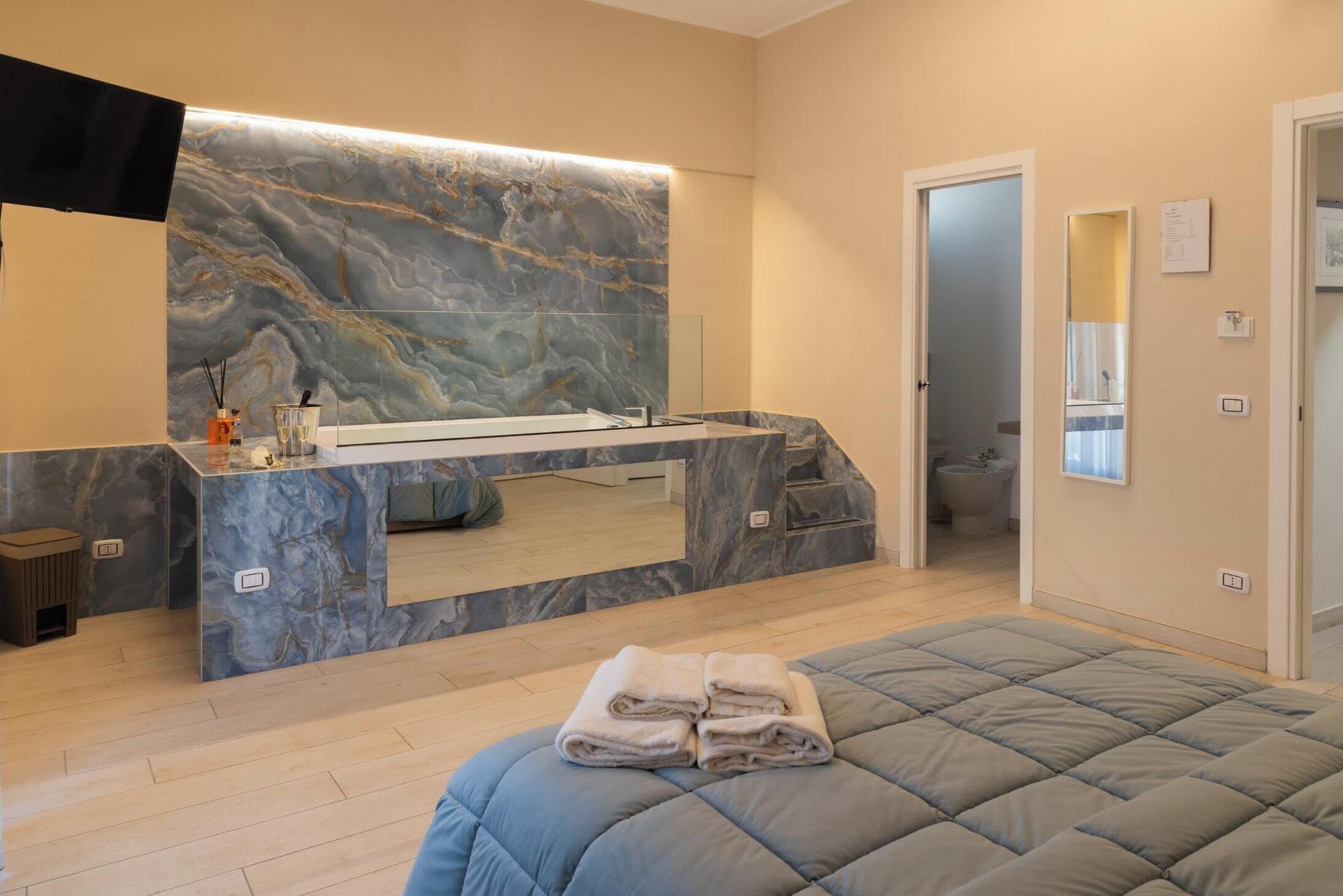Un baño moderno con tocador de mármol, un espejo grande y zona de ducha separada.