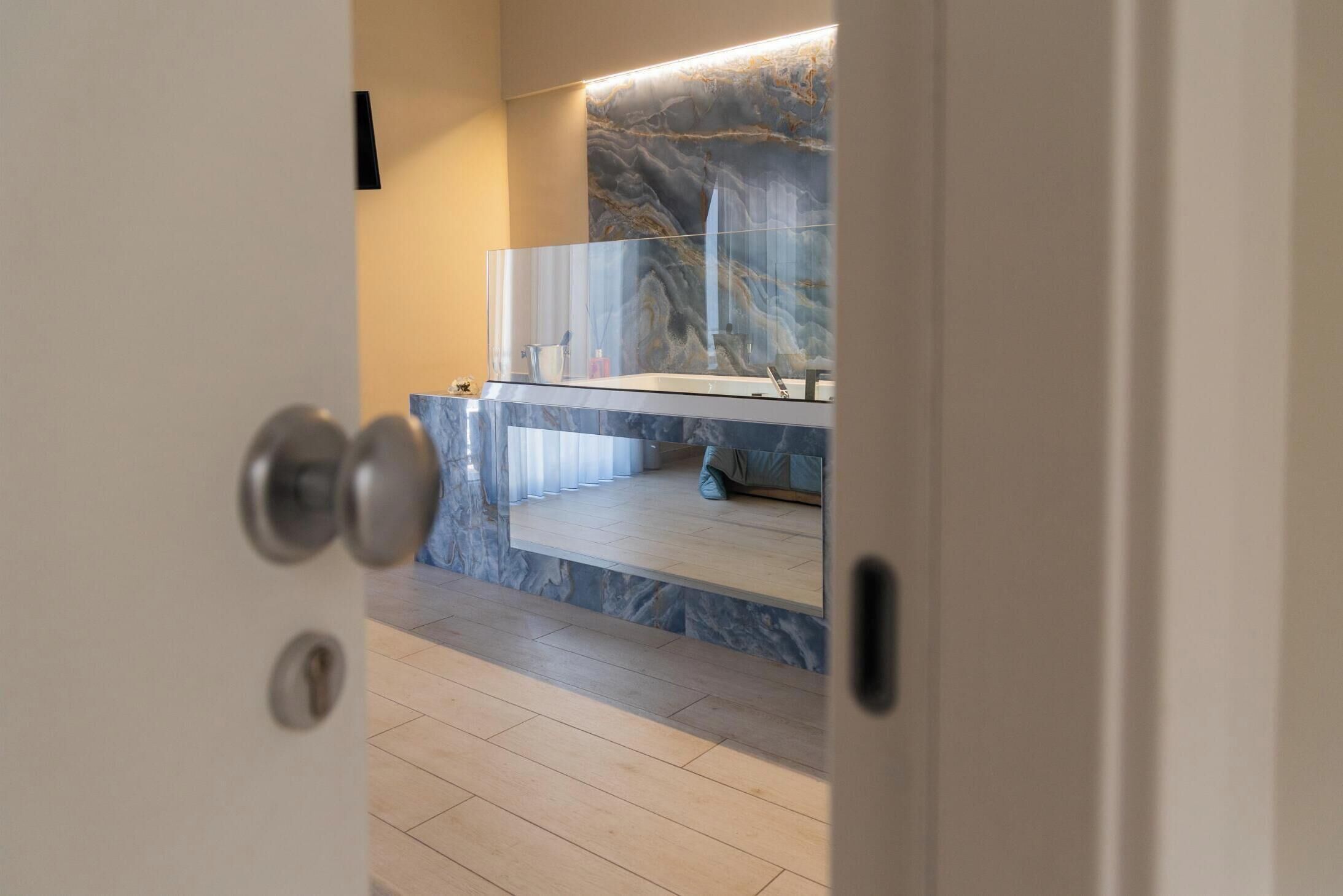 A modern bathroom with a marble countertop, a glass shower enclosure, and a visible sink.