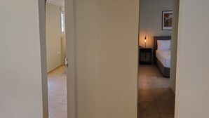 A narrow hallway with a tiled floor leading to a bedroom. - Tranquil 2BR Penthouse Petralona (Athina)