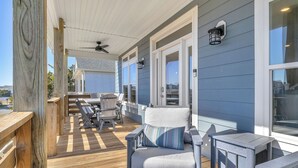 Una terraza cubierta al aire libre con mobiliario de madera, incluyendo una silla y una mesa.