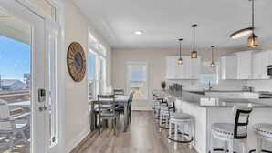 Una cocina moderna con armarios blancos, una isla grande e iluminación colgante.