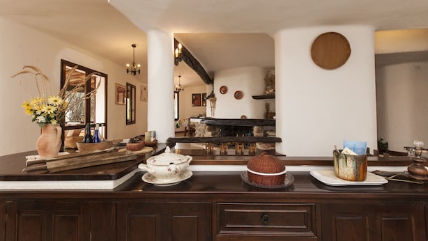 Una cucina con un piano di lavoro in legno, un camino in pietra e un'area pranzo con tavolo e sedie.