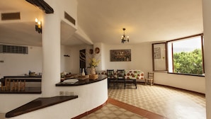 Un'ampia cucina con zona pranzo, una grande finestra vista e pavimento piastrellato.
