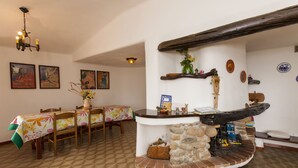 Un'area pranzo con tavolo e sedie in legno, un bancone in pietra e un lampadario.