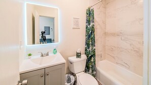 A modern bathroom with a white sink, a toilet, and a bathtub.
