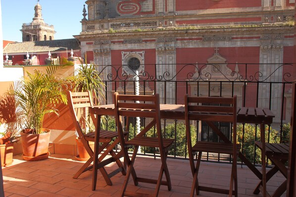 Enjoy the historic view from this balcony with ornate architecture, clock tower, and potted plants.