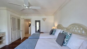 Un dormitorio con dos camas, un ventilador de techo y un armario.