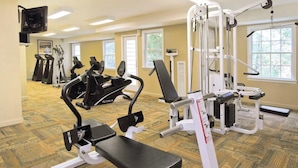 A gym with various exercise equipment, including treadmills, a bench press, and weight machines. - Available February 17-21 2025. Sleep 8 - 2-bed apt on Jiminy Peak.  Ski in/out! (Hancock)