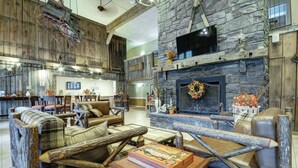 A rustic interior with a stone fireplace, wooden furniture, and a bar area. - Available February 17-21 2025. Sleep 8 - 2-bed apt on Jiminy Peak.  Ski in/out! (Hancock)