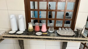A bar area with a marble countertop, various drink dispensers, and a tray of glasses.