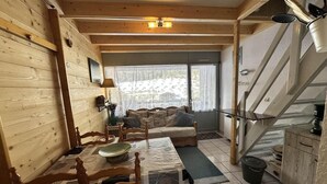 Een gezellig vakantiehuisje met een eethoek, bank en trap.