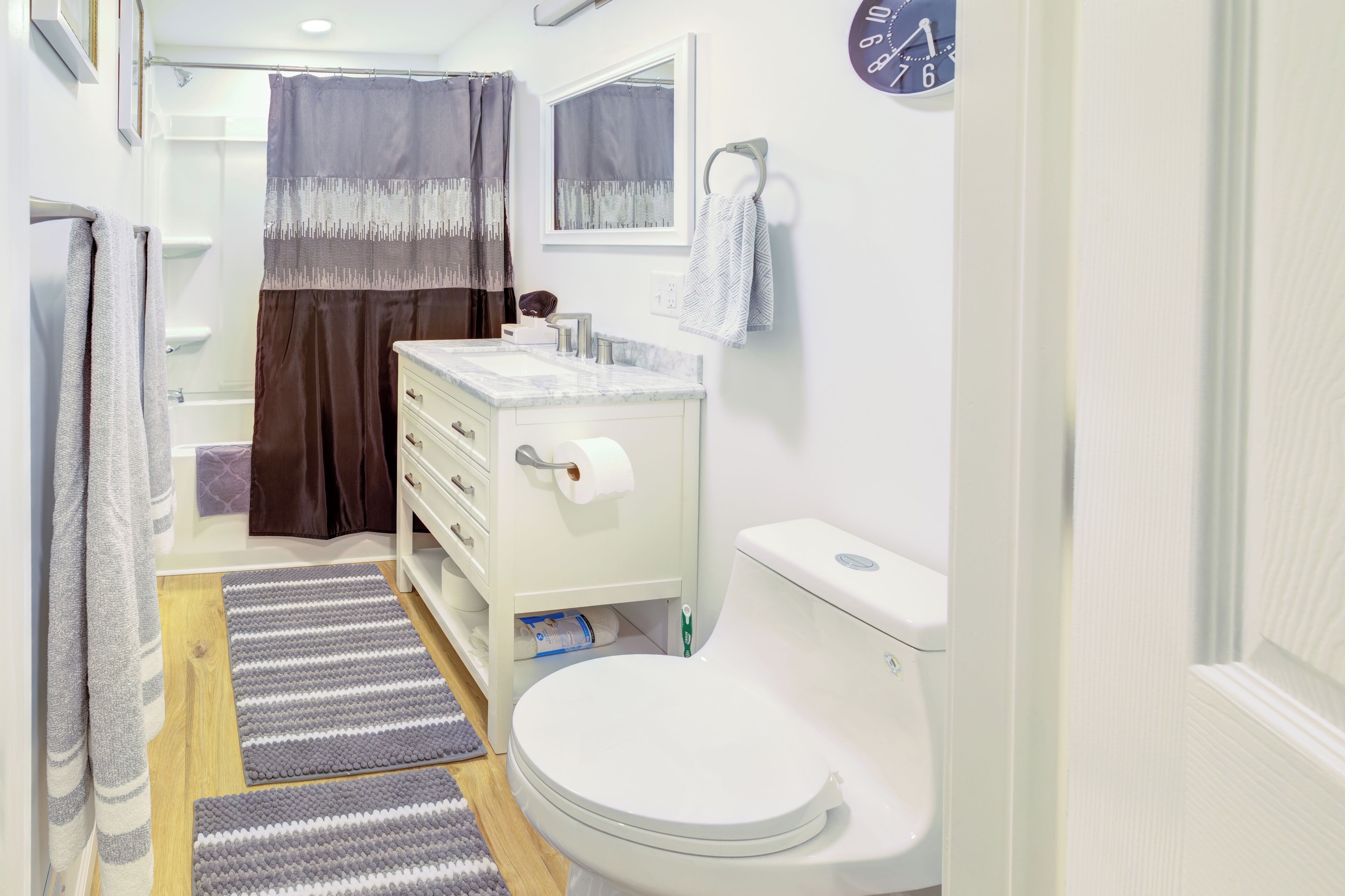 A bathroom with a toilet, sink, and shower area.