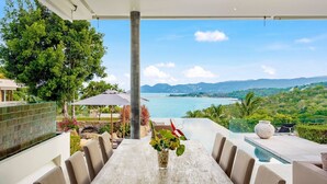 A dining area with a view of a lake and mountains. - Samujana Villas - Villa Karawek (Bo Put)